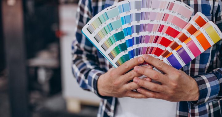 Man working in printing house with paper and paints